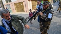 A Taliban special forces officer pushes a journalist covering a demonstration by women protesters outside a school in Kabul. (file photo)