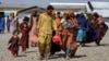 Afghan returnees carrying their belongings arrive from Pakistan at a registration center in the Takhta Pul district of Afghanistan's Kandahar Province. According to the United Nations, more than 2.6 million Afghans have returned home from Pakistan since a mass expulsion campaign began in 2023.