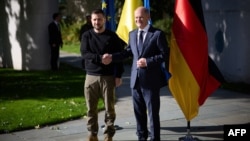 German Chancellor Olaf Scholz (right) shakes hands with Ukrainian President Volodymyr Zelensky upon his arrival for talks in Berlin on October 11.