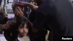 Инсерт од видео на кое активисти проверуваат деца за кои велат дека можно е да биле жртви на напад со хемиско оружје. 