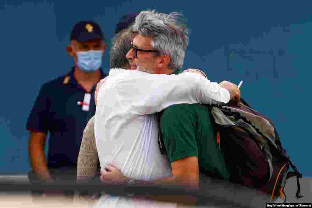 Two men embrace after a flight from Kabul landed in Rome, Italy, on August 16.