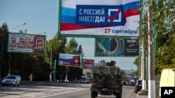 Плакати за присъединяването към Русия се появиха из градовете, където се провеждат референдумите. 