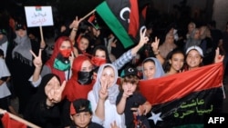 Women and children, mostly Libyans, gather outside the Libyan Embassy in Tunis on August 21, where the insurgents' flag was hoisted on the roof of the building.