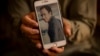 Amal Ahmadi holds a mobile phone with a picture of his brother Zemerai Ahmadi, who was one of 10 civilians killed in a U.S. drone strike on August 29. (file photo)