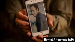 Amal Ahmadi holds a mobile phone with a picture of his brother Zemerai Ahmadi, who was one of 10 civilians killed in a U.S. drone strike on August 29. (file photo)