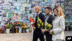 Canadian Prime Minister Mark Carney, Ukrainian President Volodymyr Zelenskyy, and first lade Olena Zelenska attend a flower-laying ceremony at the Memory Wall of Fallen Defenders of Ukraine in Kyiv on August 24.