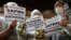 Protesters hold placards during a rally by foreign-currency mortgage holders at Raiffeisen Bank in Moscow in February last year. 