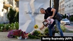 A man lays flowers at a memorial to journalist Pavel Sheremet on the site where Sheremet's car exploded on the fourth anniversary of his death in Kyiv on July 20.