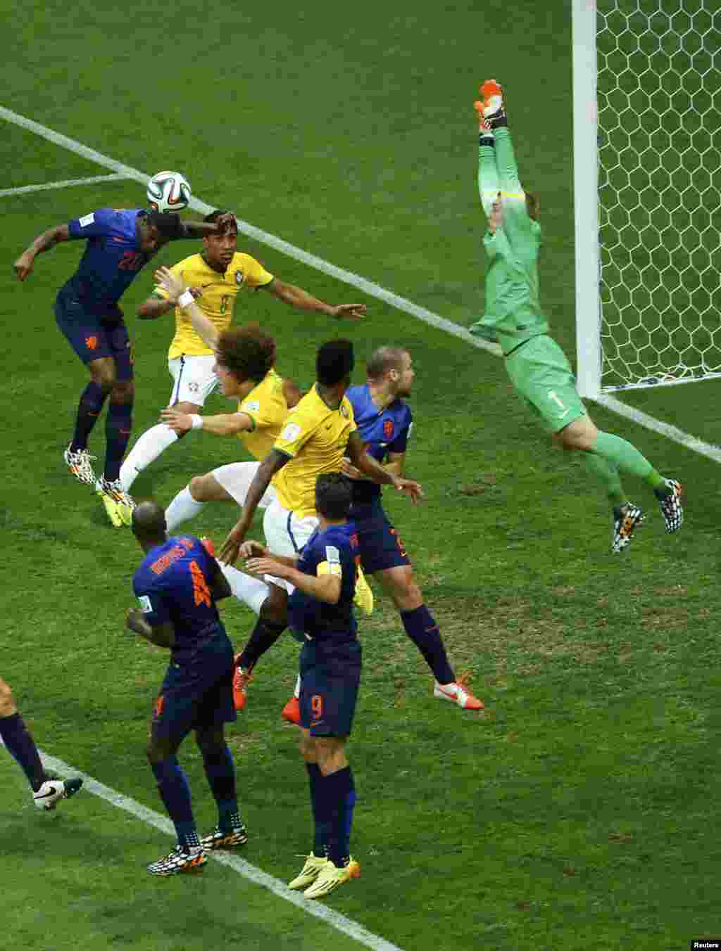 Georginio Wijnaldum of the Netherlands (top L) clears the ball after a free kick for Brazil during their 2014 World Cup third-place playoff at the Brasilia national stadium in Brasilia July 12, 2014