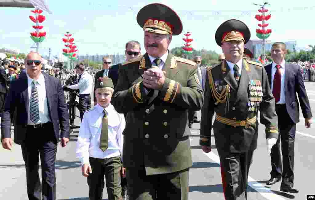 2013 год. Лукашэнка з сынам Мікалаем на парадзе на 3 ліпеня. Малодшы сын зьявіўся ў публічным полі ў 2008 годзе, паступова стаў пастаянным публічным спадарожнікам свайго бацькі. Хто маці Мікалая, афіцыйна не абвяшчалася, але распаўсюджана думка, што гэта былая асабістая доктарка Лукашэнкі Ірына Абельская