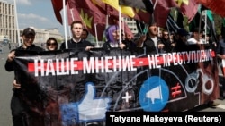 People carry a banner reading "Our opinion is not a crime" during a rally against a court decision to block the Telegram messenger service in Moscow on May 13. 