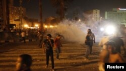 Egypt -- Protesters throw rocks and run away from tear gas on Tahrir Square in Cairo, 28Jun2011