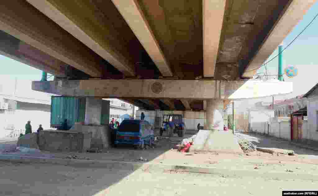 Köpriniň aşagynda galan-gaçan harytlarynyň ýygnaýan söwdagärler.