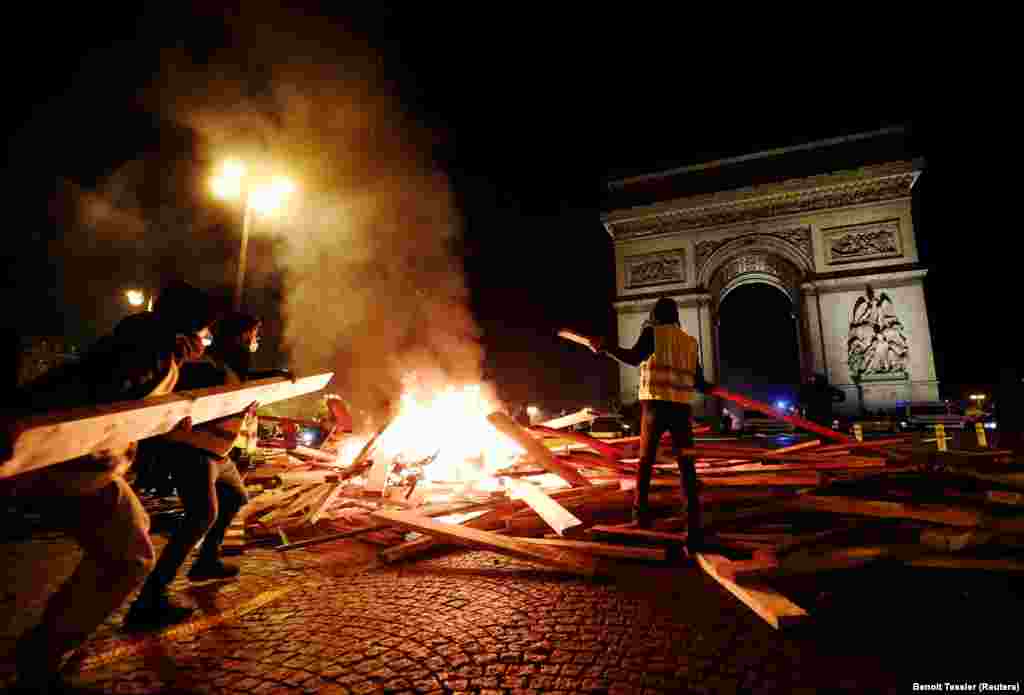 Protestatarii declanșează incendii în timpul protestelor &bdquo;Vestelor galbene&rdquo; împotriva creșterii prețului la combustibili pe bulevardul Champs-Elysees din Paris, Franța, pe 24 noiembrie. (Reuters / Benoit Tessier)