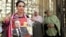 A woman holds a poster of ousted president Hosni Mubarak as she stands outside the military hospital where he was transfered after suffering a stroke in prison in Cairo.