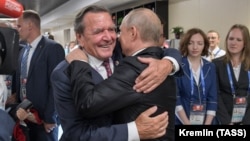 Gerhard Schroeder (left) hugs Russian President Vladimir Putin at the opening of the 2018 FIFA World Cup in Moscow in June 2018.
