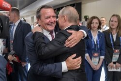 Gerhard Schröder volt német kancellár átöleli Vlagyimir Putyin orosz elnököt a labdarúgó vébé nyitóünnepségén a Luzsnyiki Stadionban, Moszkvában 2018. június 14-én