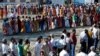 Voters line up to cast their votes outside a polling station during the first phase of general election in Alipurduar district in the eastern state of West Bengal on April 11.