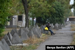 Місцевий житель відпочиває на лавочці в оточенні «зубів дракона», 20 жовтня 2024 року