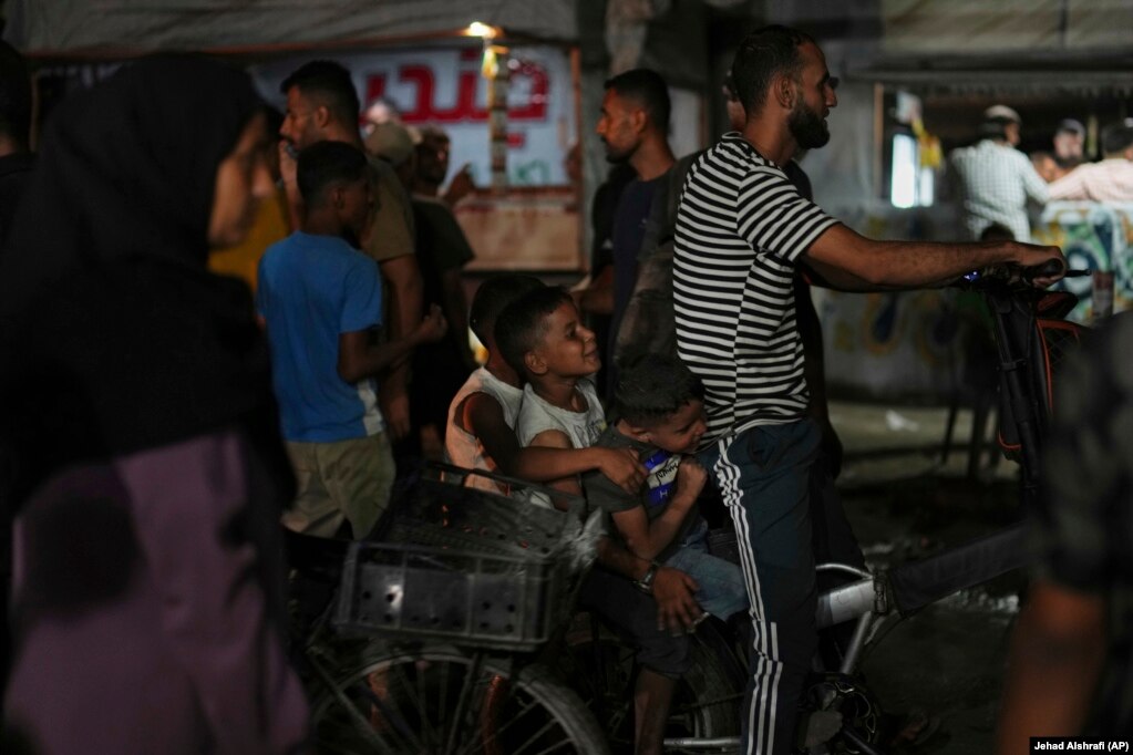 Fëmijë palestinezë duke u vozitur me biçikletë në një zonë pranë plazhit.