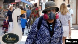 Një grua mban maskën mbrojtëse në një treg në Paris, gjatë kohës së pandemisë. 