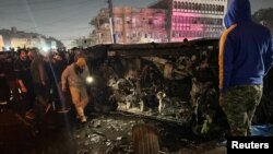 ხალხი ათვალიერებს ავტომანქანას, რომელზეც დრონით თავდასხმა განხორციელდა. მასში „კატაიბ ჰეზბოლას“ მეთაური იმყოფებოდა. 7 თებერვალი, 2024 წელი