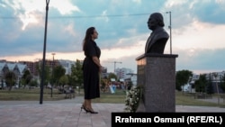 Flora Rrecaj pranë statujës së babait të saj, Idriz Rrezaj, i cili u zhduk gjatë luftës së vitit 1999.