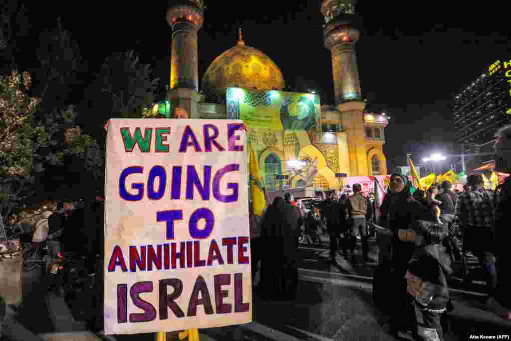 An man holds a sign in Tehran as crowds in the Iranian capital celebrate the rocket attacks. Israel has vowed to respond to the strikes, with Prime Minister Benjamin Netanyahu calling them &quot;a big mistake,&quot; which Tehran &quot;will pay for.&quot;&nbsp;