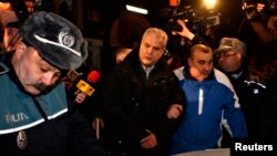 Полиция Румынияның бұрынғы премьер-министрі Адриан Нэстасені (ортада) түрмеге апара жатыр. Бухарест, 6 қаңтар 2014 жыл.