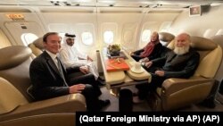 Ричард Ліндсей (ліворуч) із подружжям Рейнолдс на літаку до Катару