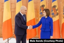 Ilie Bolojan și Maia Sandu, își strâng mâna după conferința lor de presă comună, la Președinția de la Chișinău, 1 martie 2024