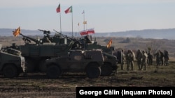 Echipamente militare la Cincu, purtând drapele ale mai multor țări aliate NATO.