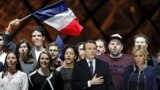 French President elect Emmanuel Macron and his wife Brigitte Trogneux celebrate on the stage at his victory rally near the Louvre in Paris