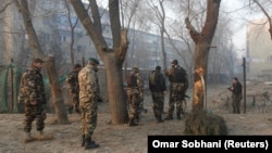 Afghan security forces inspect the site of a suicide attack in Kabul on January 5.