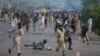 Antigovernment protesters run after police personnel during the Revolution March in Islamabad on September 1.