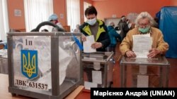 Виборці опускають бюлетені в урну на одній із виборчих дільниць Харкова. Місцеві вибори 25 жовтня 2020 року