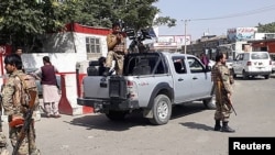 Afghan security forces stand guard at the entrance gate of Hamid Karzai International Airport in Kabul on August 15.