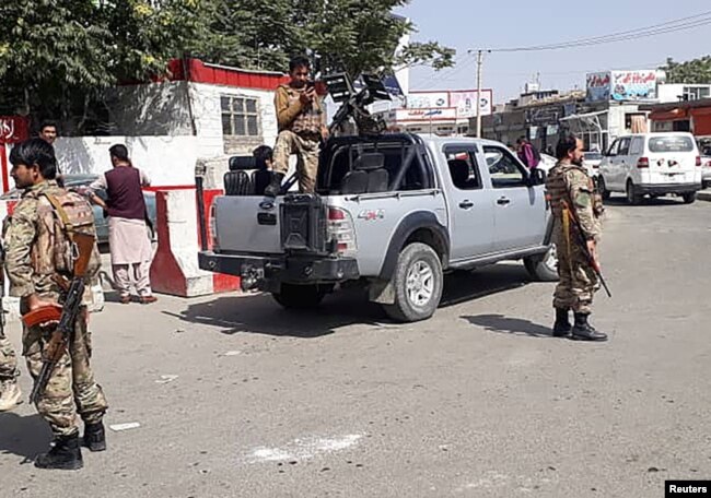 Afghan security forces stand guard at the entrance gate of the airport in Kabul on August 15. - Taliban