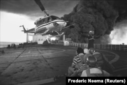 A helicopter arrives to pluck sailors from the deck of a burning Cypriot-flagged oil tanker after it was atttacked by Iranian speedboats in the Strait of Hormuz in December 1987.
