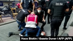 Полиция Стамбулдагы жүрүштү чагылдырган кабарчыны кармап жатат. 26-июнь 2021-жыл (иллюстрация)