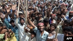 Internally displaced men block a road as they protest against the shortage of relief aid and the Pakistani government's handling of the crisis in Sukkur in September.