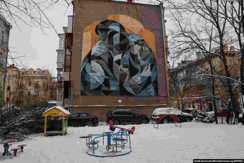 Мурал – подяка волонтерам у Києві на Подолі з’явився у червні 2023 року. На ньому зображена пара, яка застигла в обіймах. Тіла цих двох – вкривають обійми безлічі інших рук. Ці руки символізують усі благодійні фонди та громадські організації, які допомагають військовим, біженцям, жінкам, дітям і тваринам