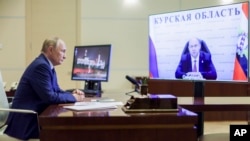 Președintele rus Vladimir Putin îl ascultă pe guvernatorul interimar al regiunii Kursk, Alexei Smirnov, în timpul unei videoconferințe la reședința președintelui rus de la Novo-Ogariovo, în apropiere de Moscova, pe 8 august, la două zile după incursiunea Ucrainei în Rusia. 