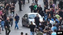 Oamenii reacționează după ce o explozie a avut loc în timpul funeraliilor celor uciși când sute de dispozitive de paging au explodat în Liban cu o zi înainte, în suburbiile de sud ale Beirutului, la 18 septembrie 2024.