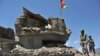 Afghan border policemen walk past a bunker, destroyed during recent clashes between Afghan border police and Pakistani troops in Goshta district of Nangarhar Province.