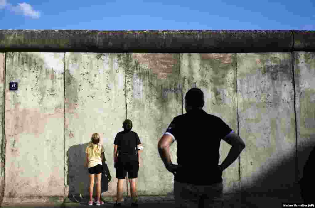Disa vizitorë duke qëndruar para rrënojave të Murit të Berlinit, në vendin përkujtimor në rrugën &quot;Bernauer&quot;, para përvjetorit të 60-të të ndërtimit të strukturës së betontë në Berlin. (12 gusht)
