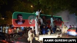 Supporters of Pakistan's cricketer-turned politician Imran Khan, head of the Pakistan Tehreek-e-Insaf (Movement for Justice) party, celebrate on a street during general election in Islamabad on July 25, 2018.