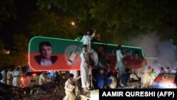 Supporters of Pakistan's cricketer-turned-politician Imran Khan, head of the Pakistan Tehreek-e-Insaf (Movement for Justice) party, celebrate on a street during the general election in Islamabad late on July 25.