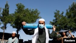 Muškarac čeka ispred fabrike da napuni cilindar s kisikom usred širenja COVID-19 u Kabulu, Afganistan, juni 2021. godine.