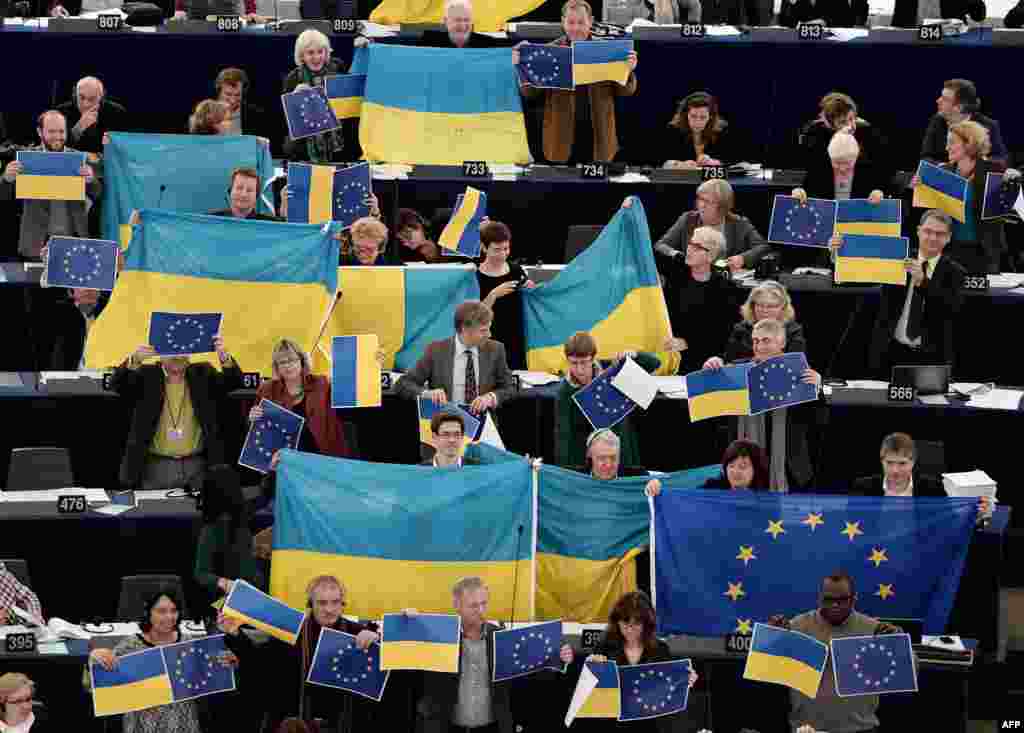 Members holding EU and Ukrainian flags vote in the European Parliament in Strasbourg. (AFP/Frederick Florin)